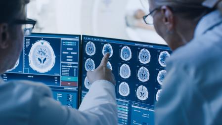 Les médecins discutent d'un diagnostic tout en observant la procédure et les moniteurs.