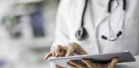Femme médecin utilisant une tablette numérique en clinique.
