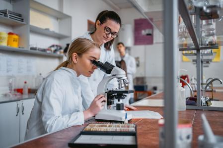 Un étudiant observant des micro-organismes au microscope