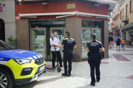 Deux agents de police locaux de Calella arrêtent le conducteur d'un scooter.
